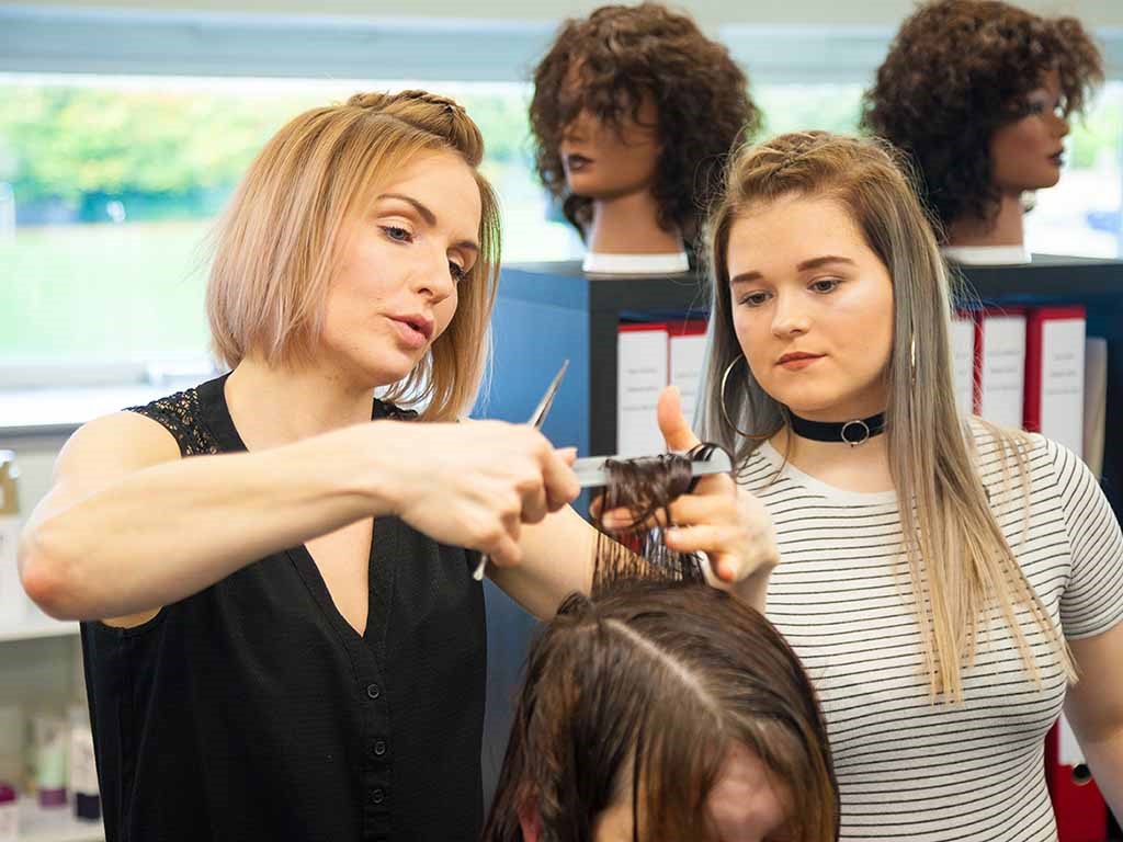 lecturer cutting hair showing student technique 
