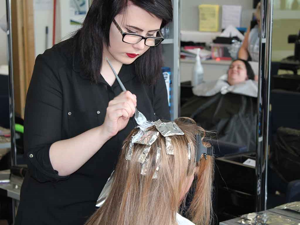 hairdresser putting hair dye on client