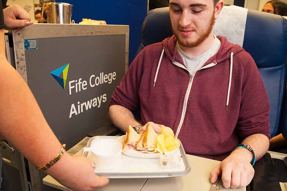 student looking at plate of food in fife college aircraft room used for student training