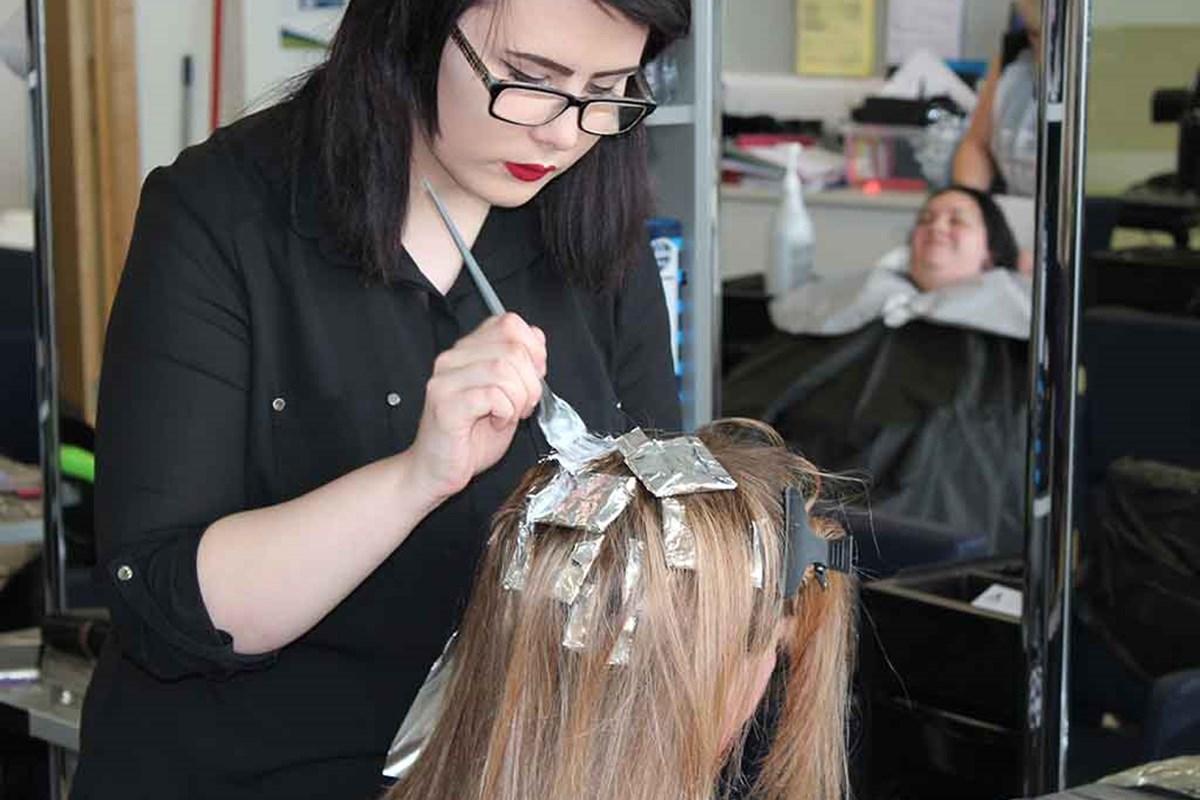 hairdresser putting hair dye on client