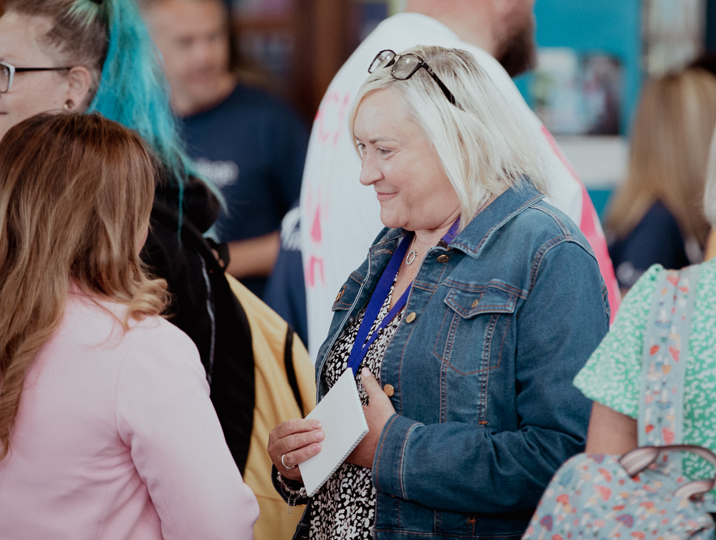 staff and student smiling and talking to each other