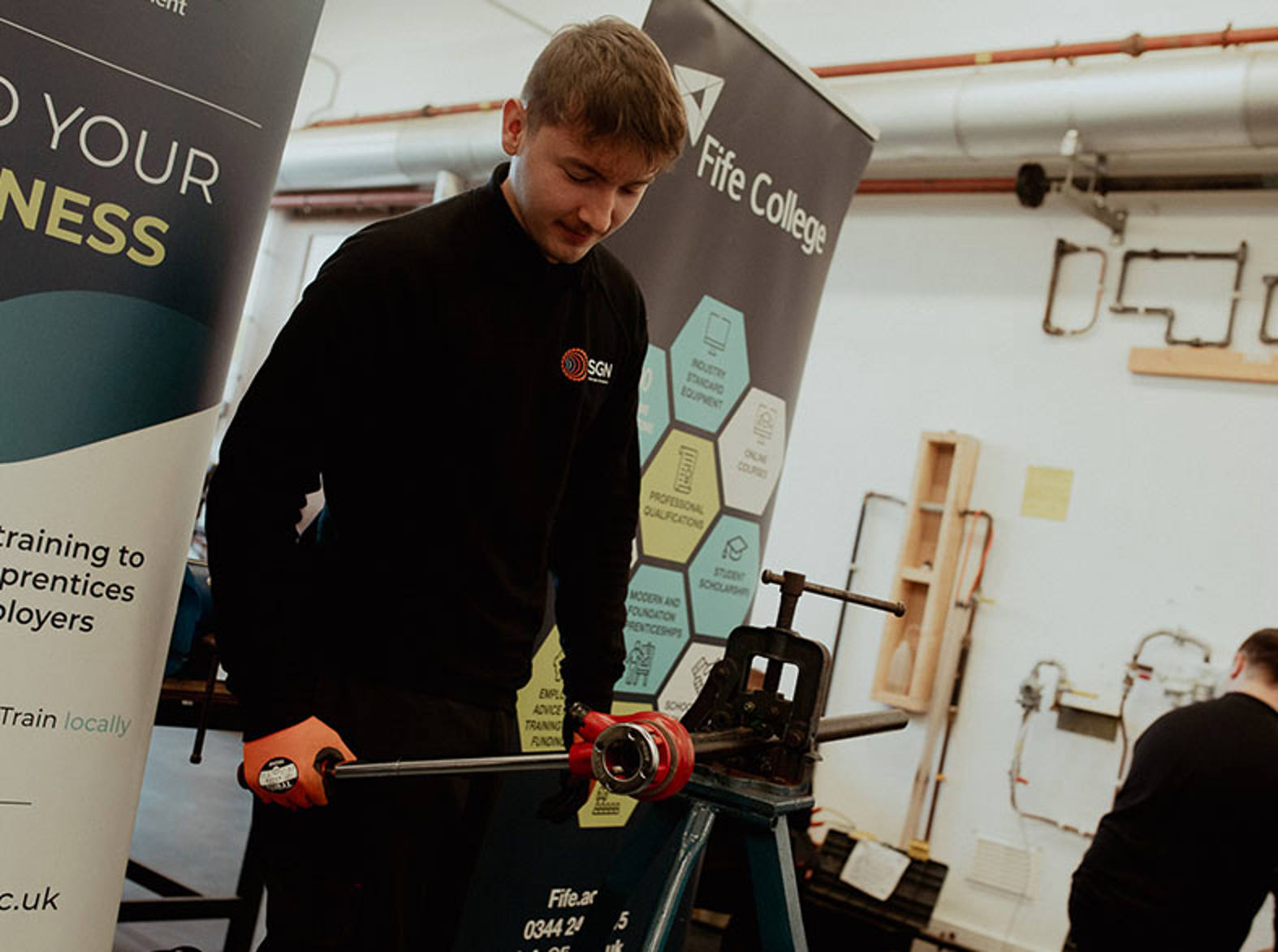 Engineering apprentice working on piece of piping