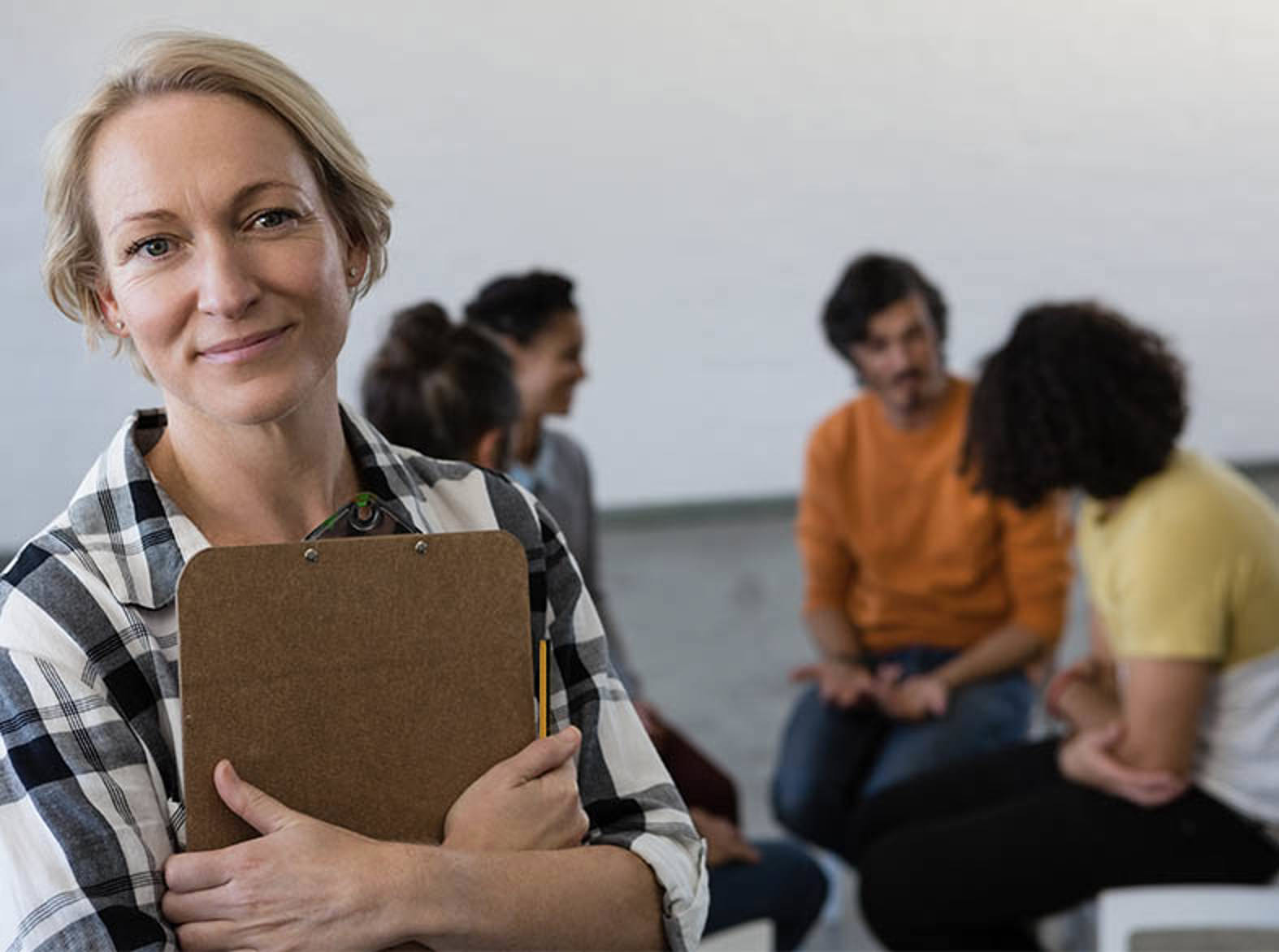 woman with clipboard and group of people in background