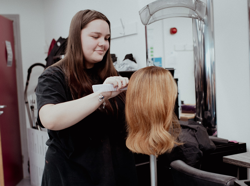 student working on mannequin hair
