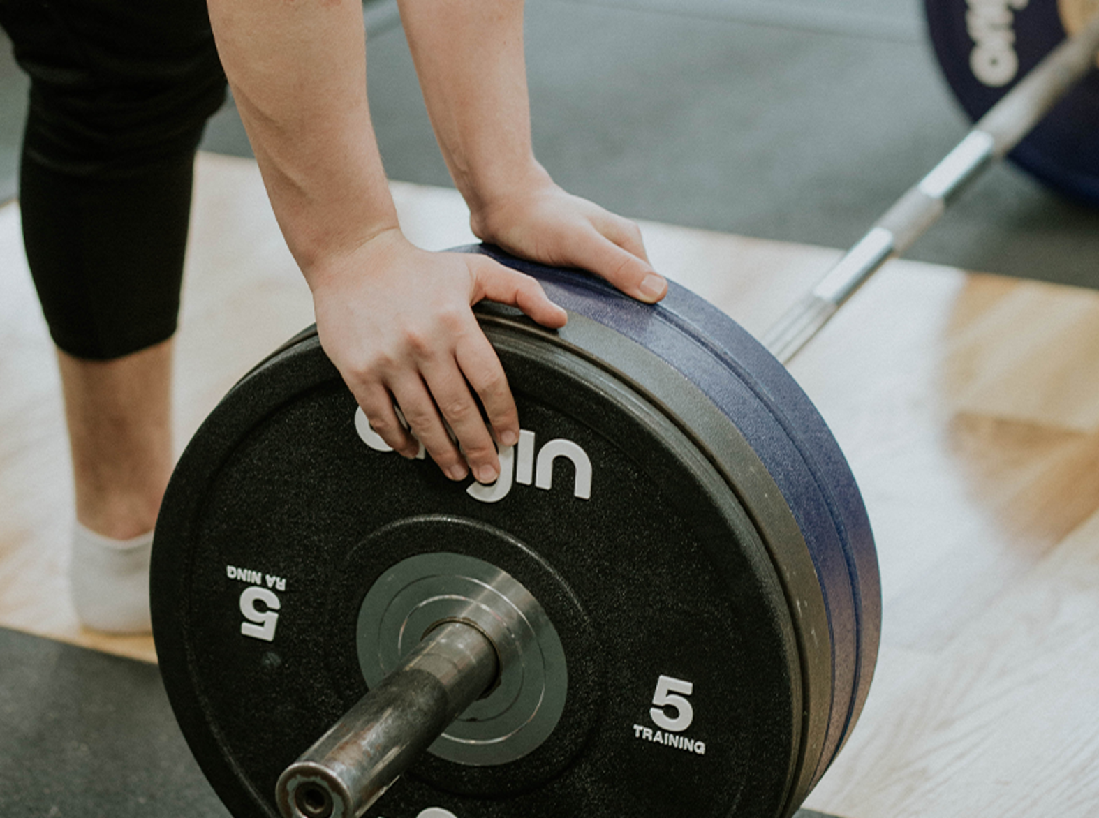 close up of someones hand changing weight on bar