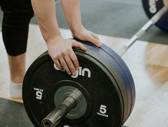 close up of someones hand changing weight on bar