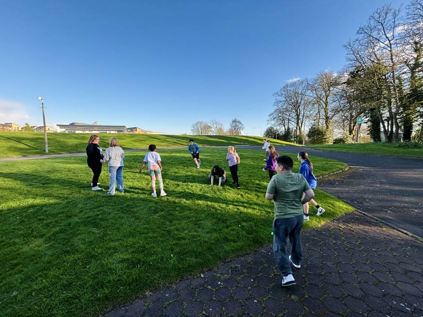 group of people outside on grass with blue skies
