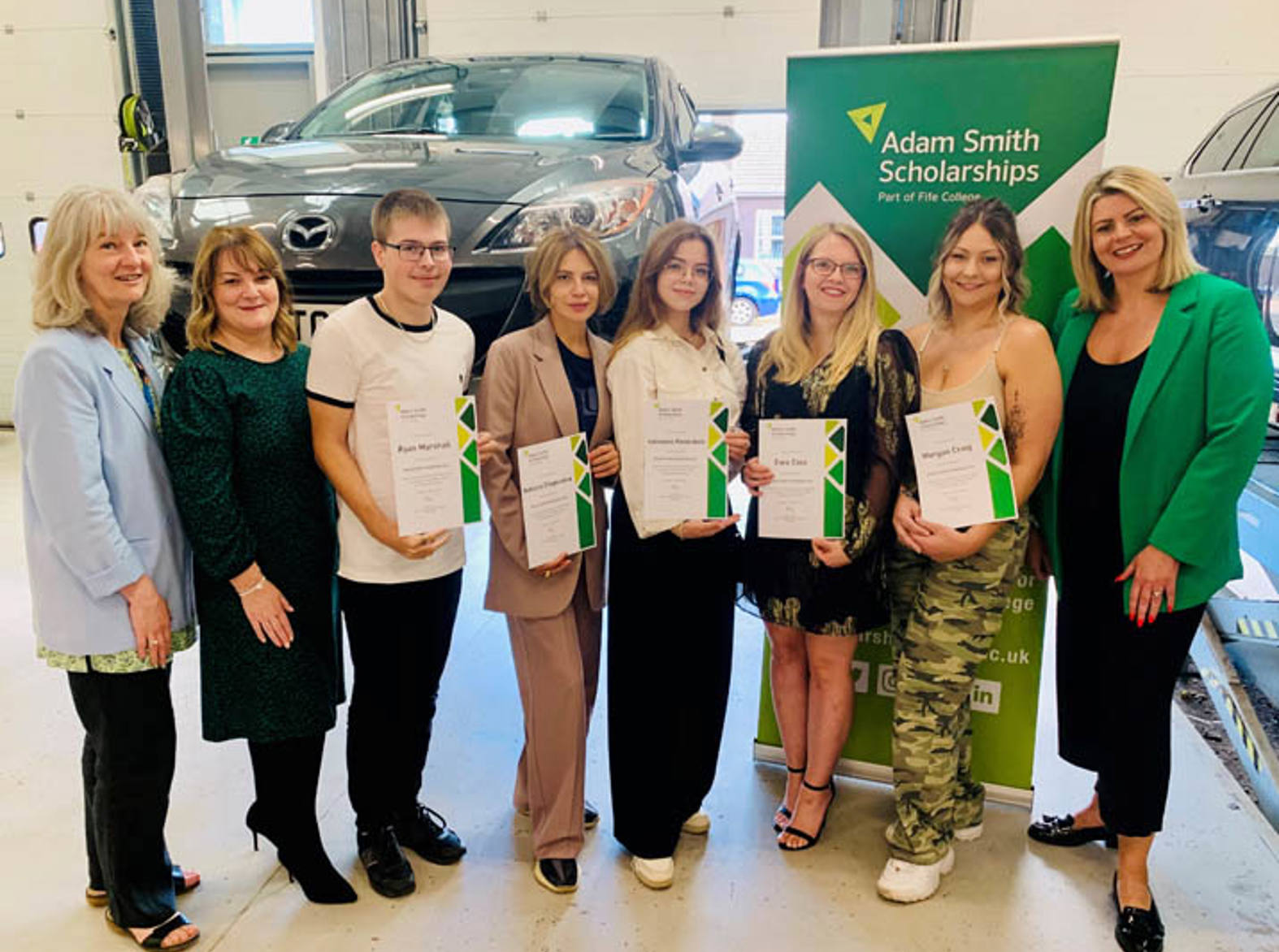 group of arnold clark scholarship winners holding certificates smiling at camera