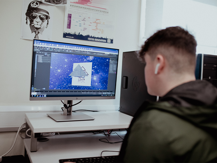 male student looking at work on computer