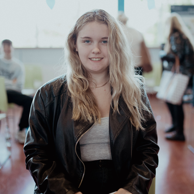 female student smiling at the camera in refectory