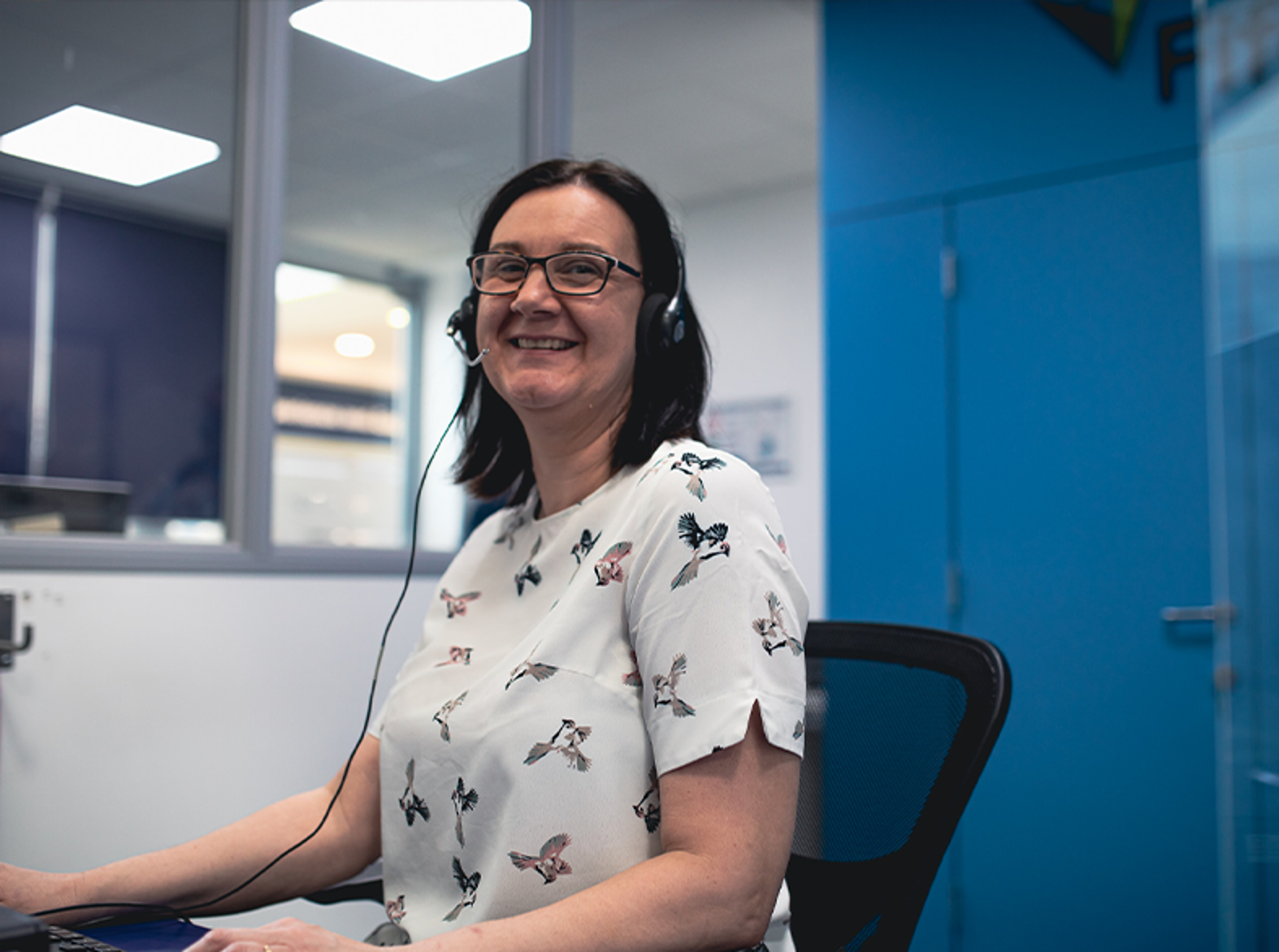 reception staff member smiling at camera wearing headset