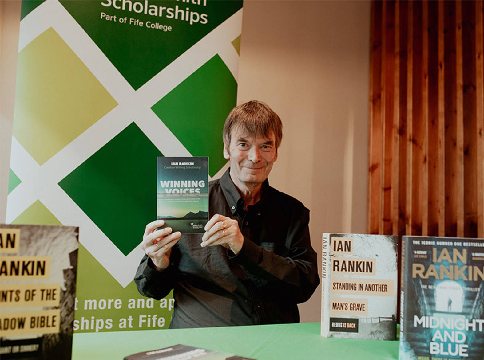 Ian Rankin holding a book