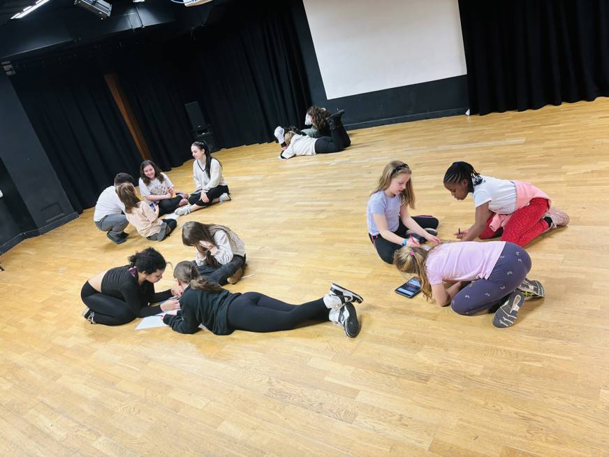 students in groups in theatre hall