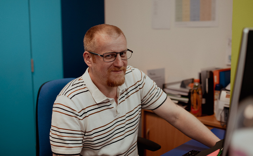 reception staff member smiling looking at computer
